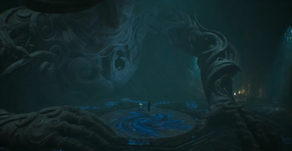 Person standing on blue-lit platform beneath giant statue