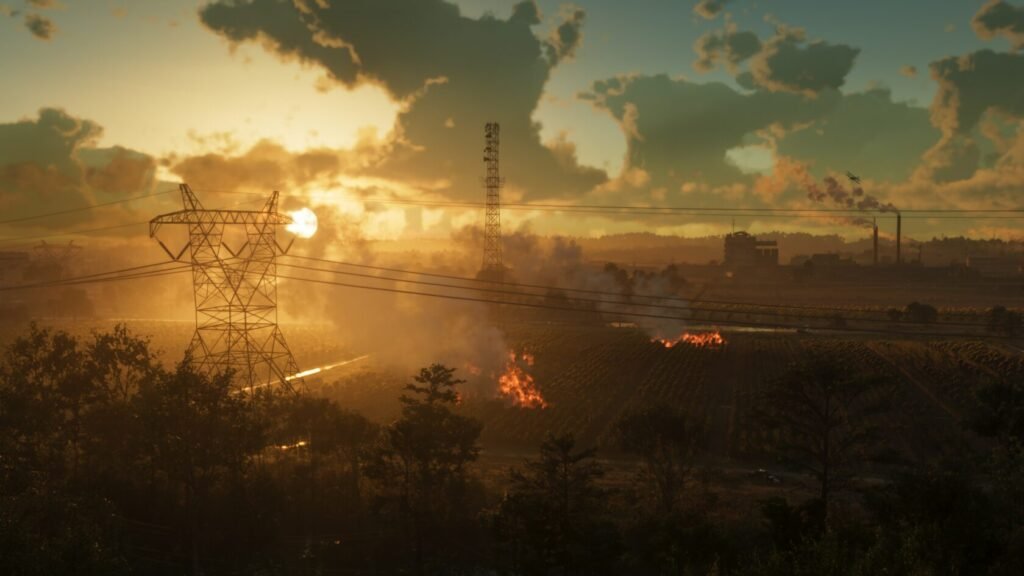Power lines crossing smoky landscape at sunset with fire