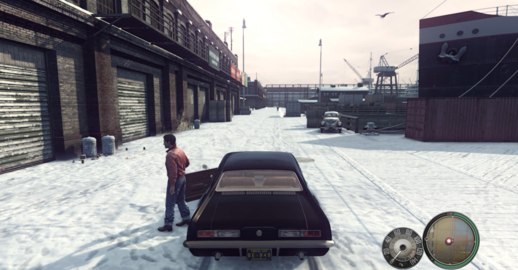 Man standing beside black car snowy street.