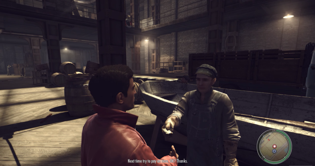 Man in red jacket talks to worker.