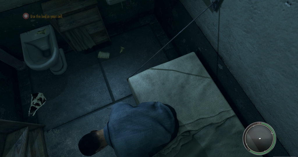 Man crouching on bed in cell.