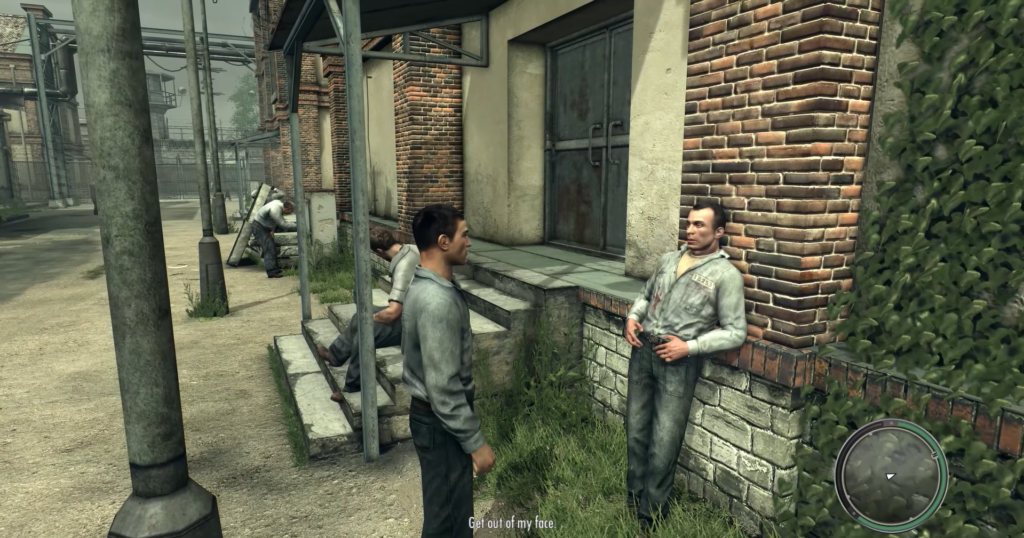 Two men talking near brick building.