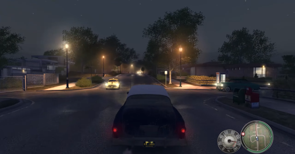 Vintage car driving on dimly lit street.