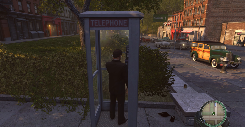 Man in suit using telephone booth.