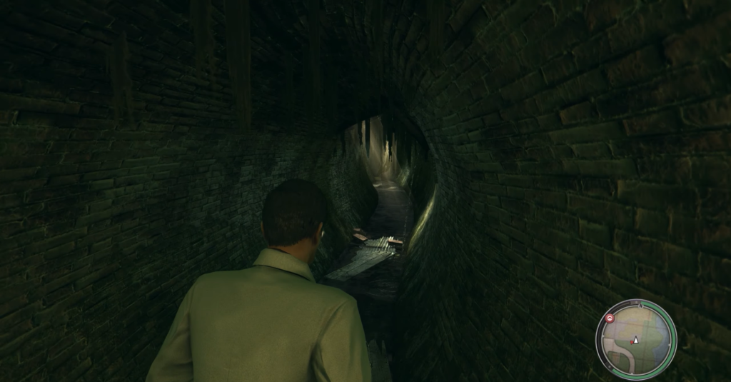 Man walking through dark, narrow tunnel.