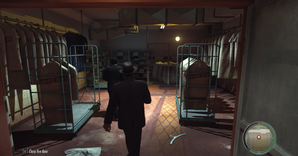 Man in suit walking past clothing racks.