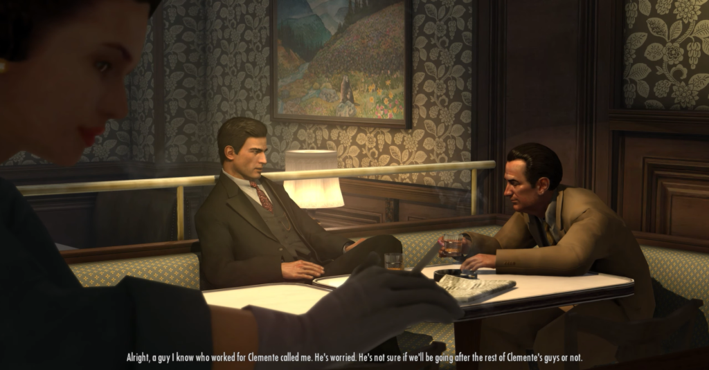 Man in suit discussing at table.