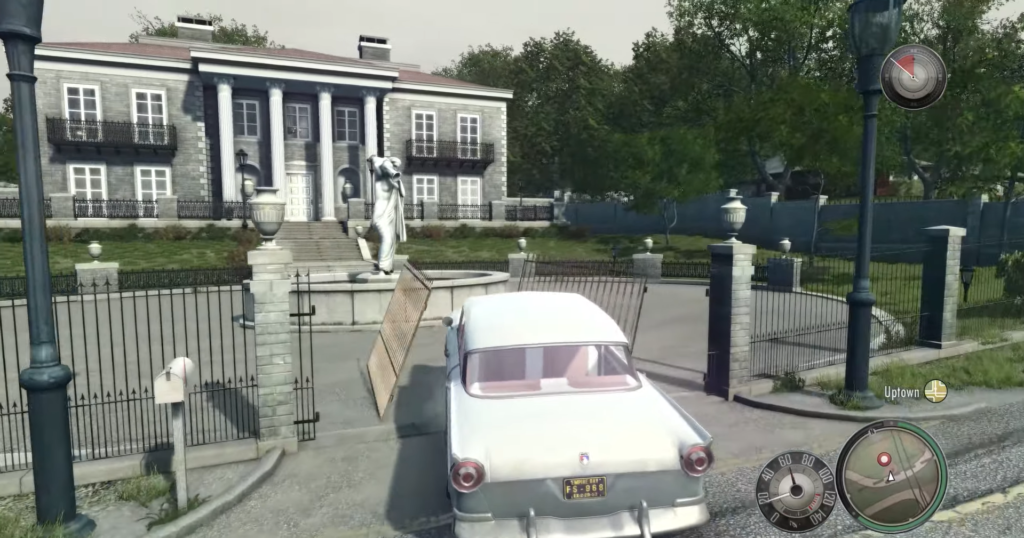 Classic white car approaching mansion gate.