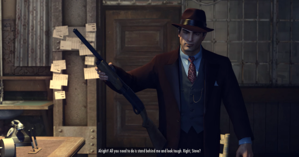 Man in suit holding shotgun indoors.