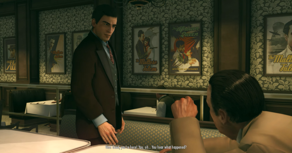 Man in suit speaks to seated man.