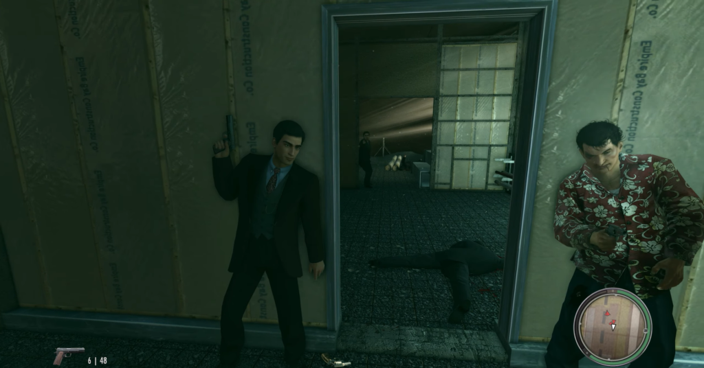 Man in suit holds gun doorway.