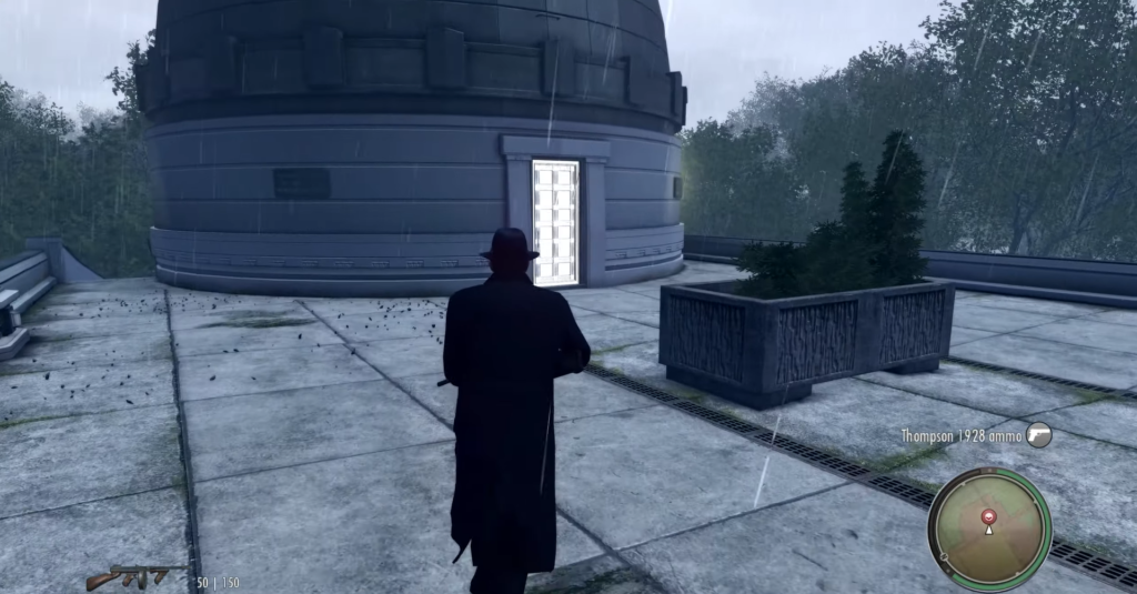 Man in black coat approaches white door.