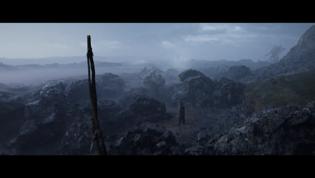 Person standing among rocky landscape under cloudy sky