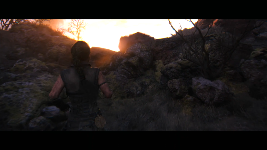 Person running through rocky hillside at sunset