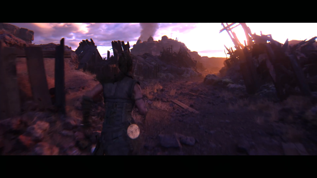 Senua runs through rocky ruins at sunset in Hellblade