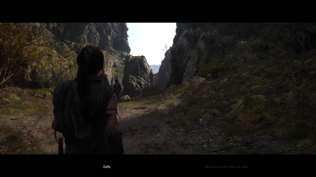 Woman walks along rocky canyon path with cliffs