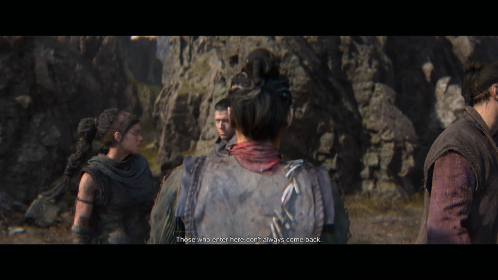 Group of people talking beside rocky cliff outdoors