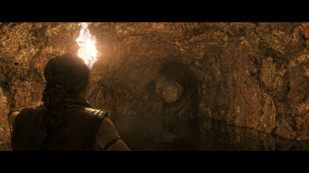 Woman holding torch in rocky cave wall