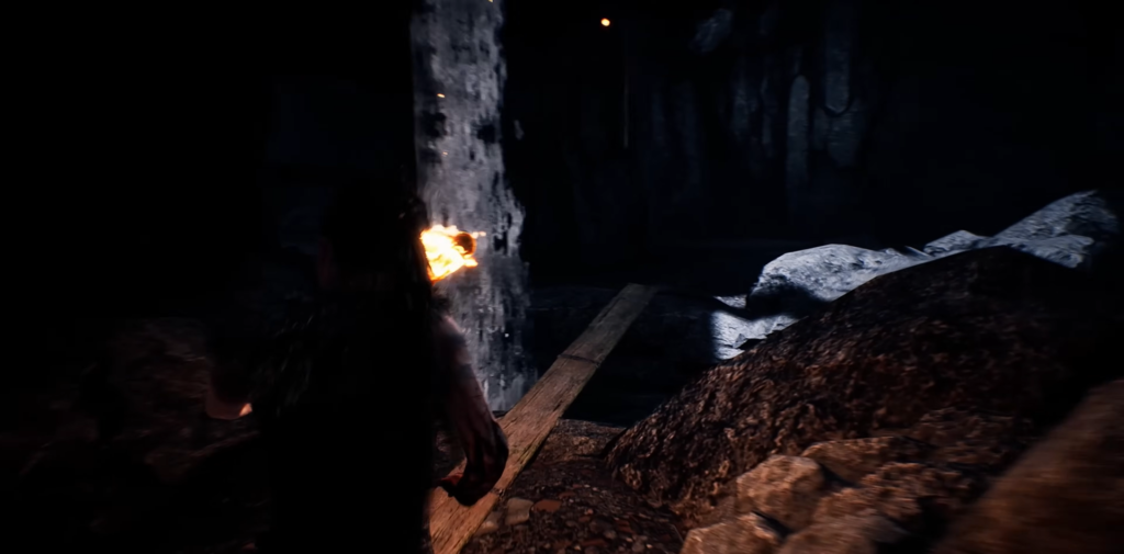 Фигура человека идет по темной пещере с огнем