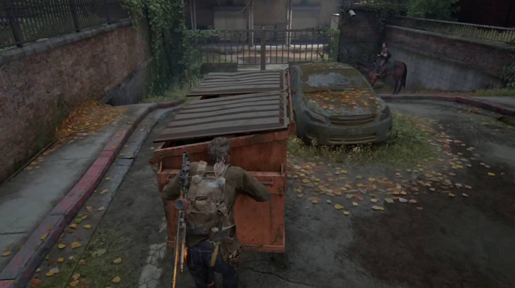 Joel pushes dumpster in The Last of Us street