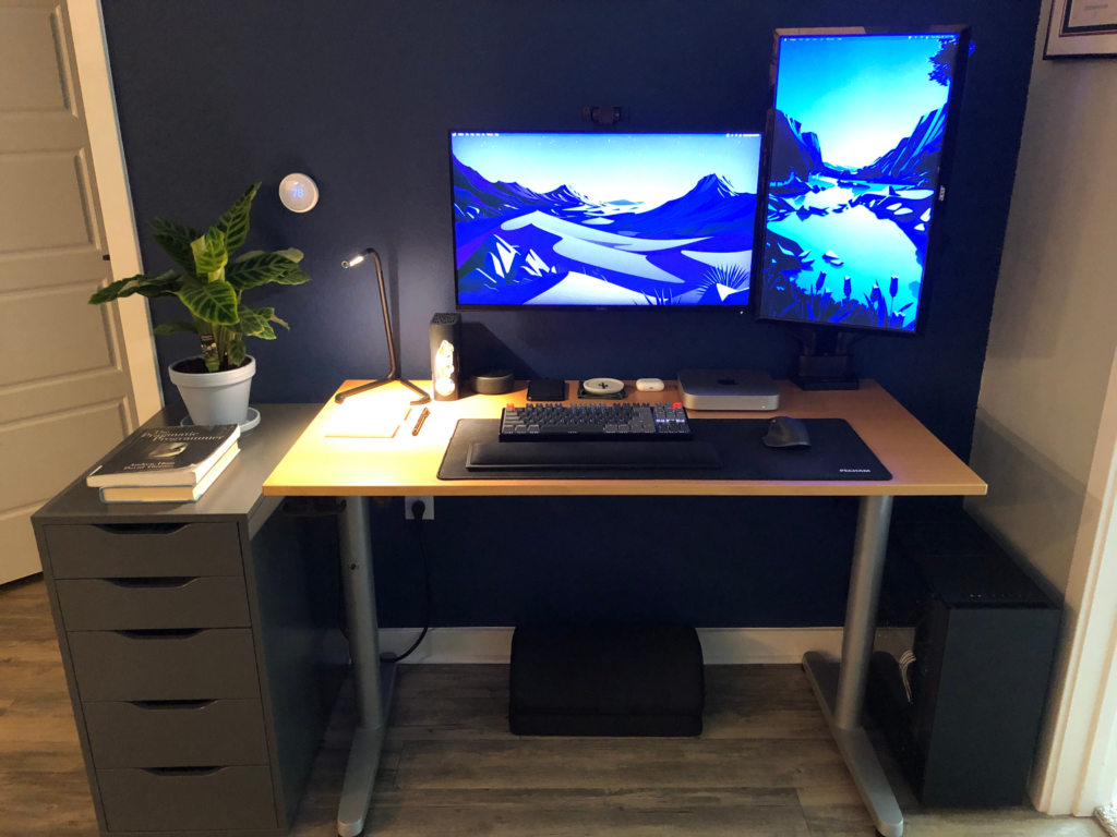 Dual monitors displaying blue landscape on home office desk