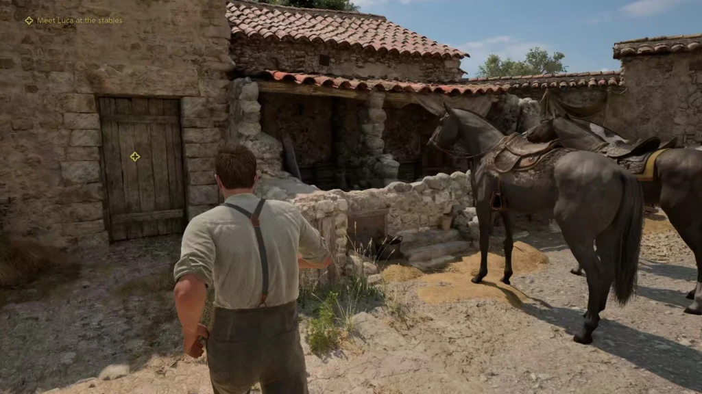 Man walking toward horses at stone stables courtyard