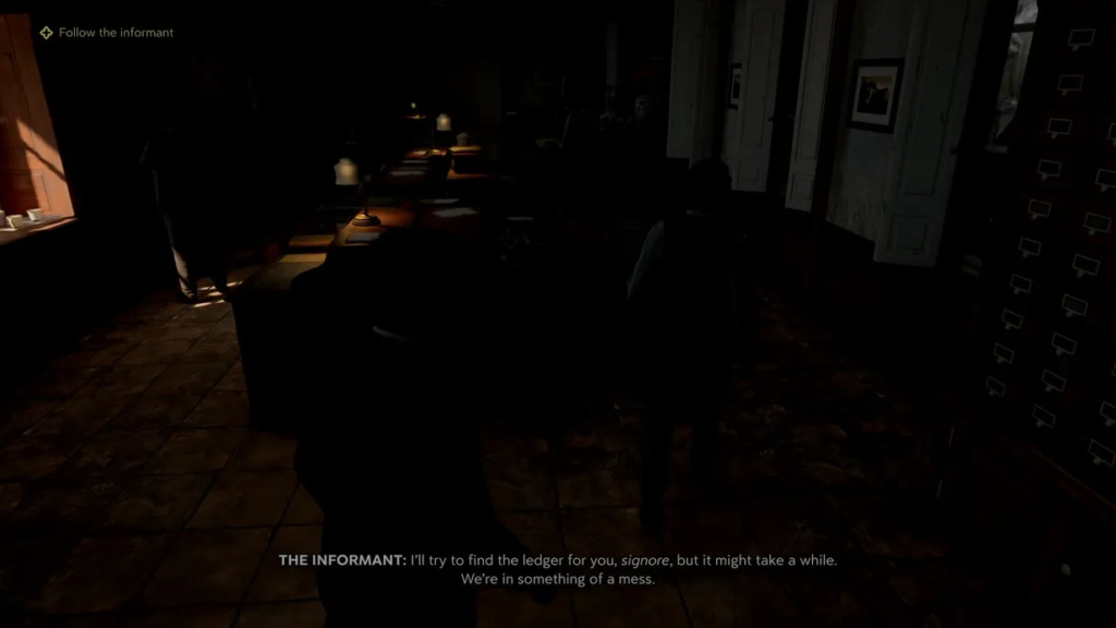 Two people walking through dim office with desks