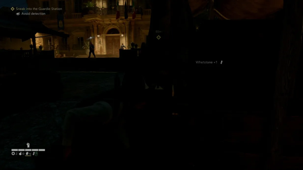 Player sneaks near guard station at night courtyard