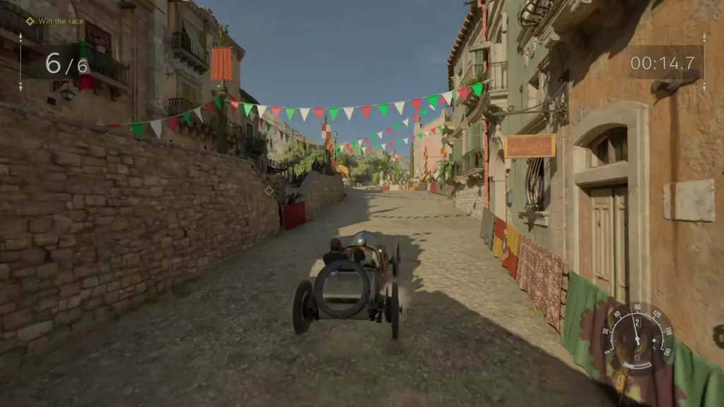 Vintage race car driving through village street with bunting