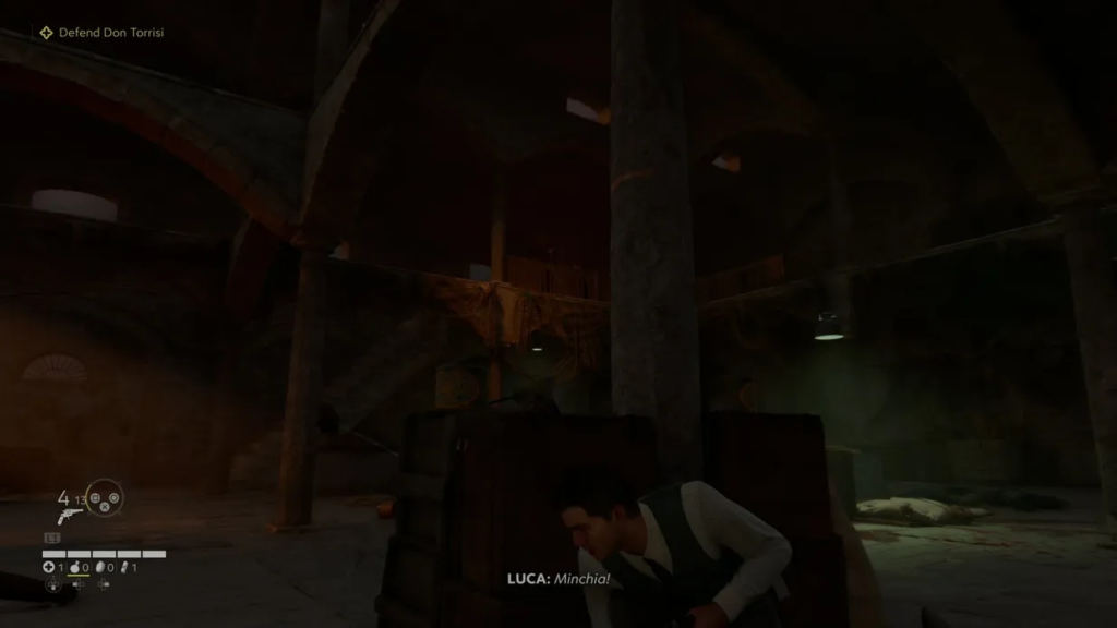 Luca crouches behind cover in Mafia II warehouse