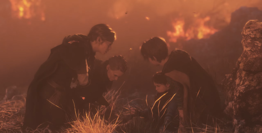 Group kneeling around child in burning field at dusk