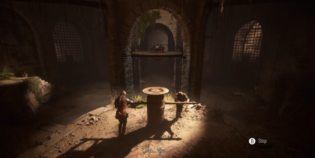 Two people turn a crank in brick chamber