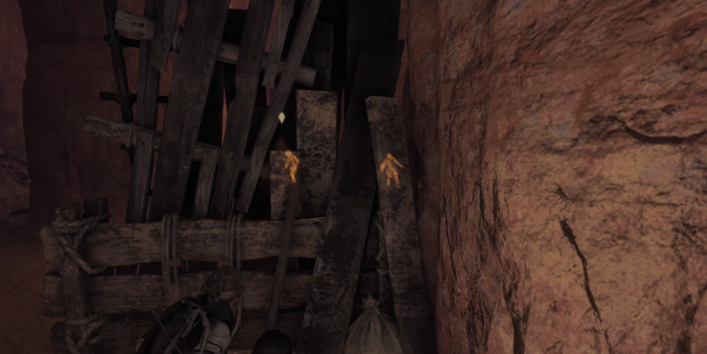 Lara Croft climbing wooden structure in cave.
