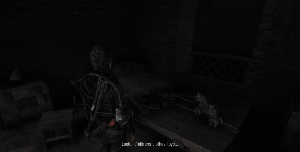 Child examines toys on a wooden table.