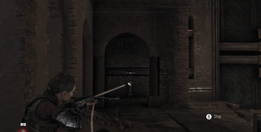 Boy aiming crossbow in dark stone corridor.