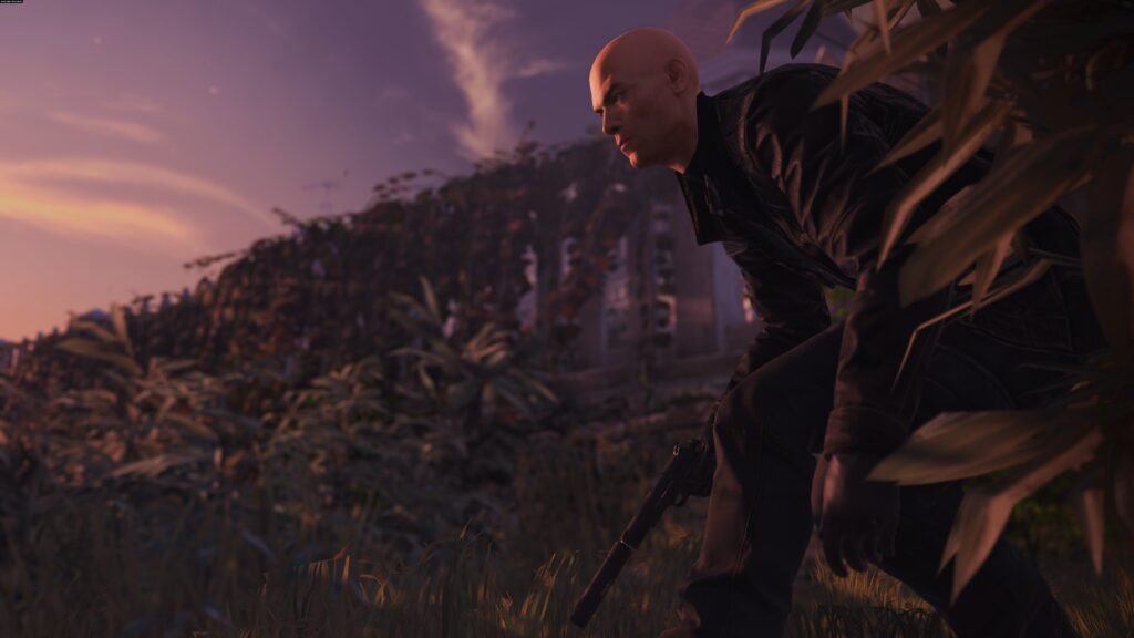 Agent 47 from Hitman crouching with pistol in grass