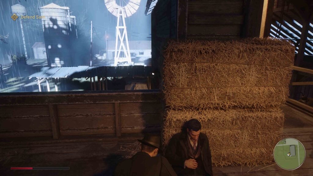 Mafia: Definitive Edition character crouching beside hay bales barn