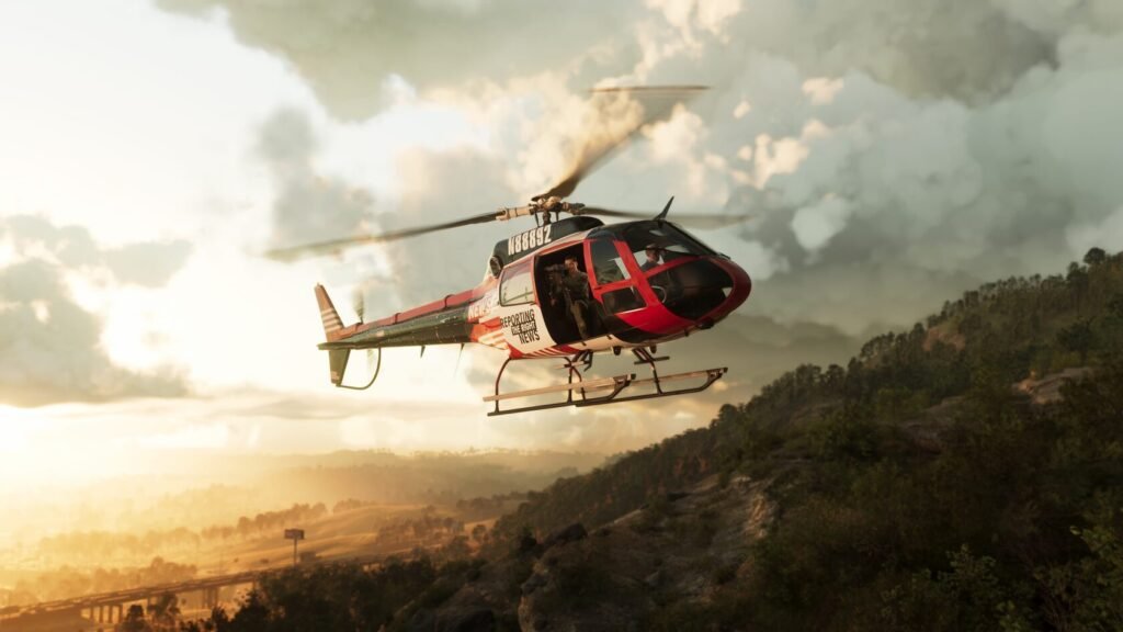 Red news helicopter flying over forested hills at sunset