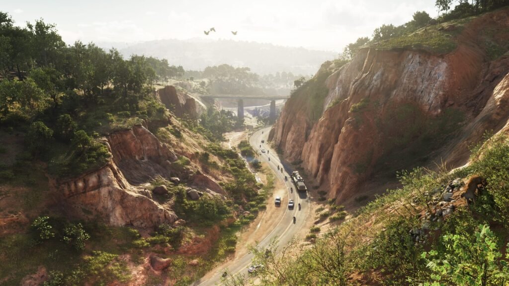 Cars drive along winding road through rocky canyon