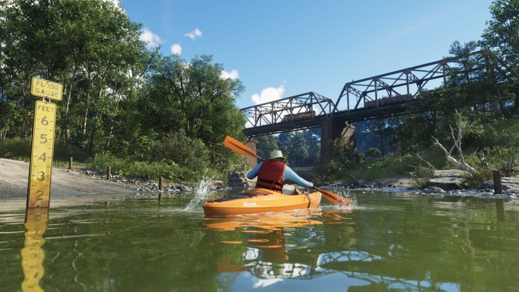 Kayaker paddling orange kayak under bridge on river